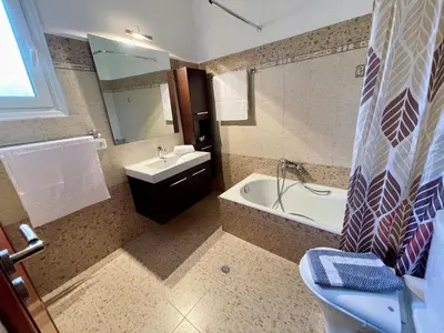 a bathroom with a tub and a sink and a toilet at Archangelos Garden House in Archangelos