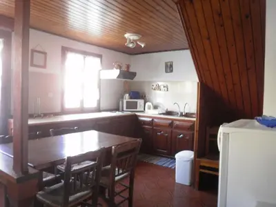 a kitchen with a wooden table and a dining room at Harbour View Apartment in Symi