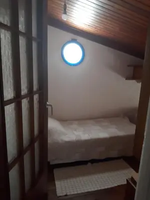 a small room with a bed and a window at Harbour View Apartment in Symi