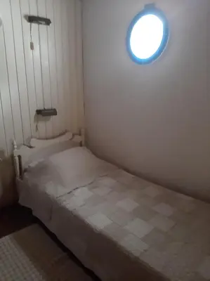 a small bedroom with a bed and a window at Harbour View Apartment in Symi