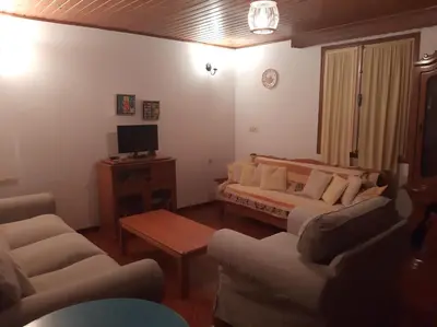 a living room with a couch and a tv at Harbour View Apartment in Symi
