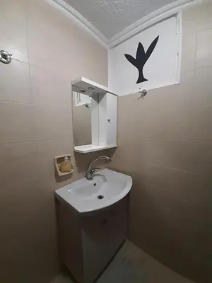 a white bathroom with a sink and a mirror at Harbour View Apartment in Symi