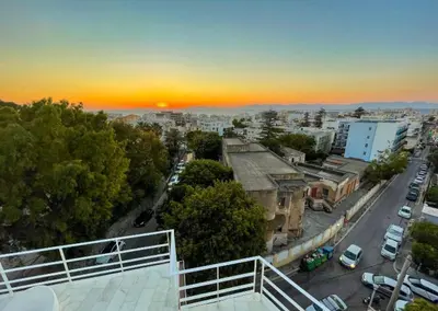 a view of a city at sunset from a balcony at Panoramic view - Penthouse in Rhodes Town