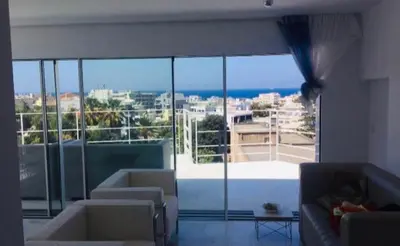 a living room with a large window with a view of the ocean at Panoramic view - Penthouse in Rhodes Town