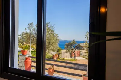 a window looking out at a view of a yard at Blue Bay Villas , Ground Floor in Archangelos