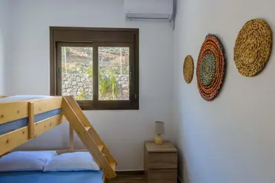 a bedroom with a bunk bed and a window at Blue Bay Villas , Ground Floor in Archangelos