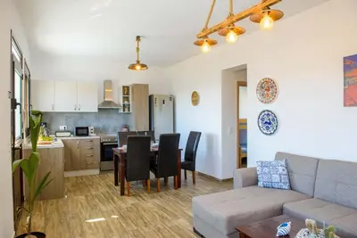 a living room and kitchen with a couch and a table at Blue Bay Villas , Ground Floor in Archangelos