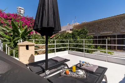 a patio with an umbrella and a table on a roof at Letty's House - Old Town Luxury Mansion in Rhodes Town