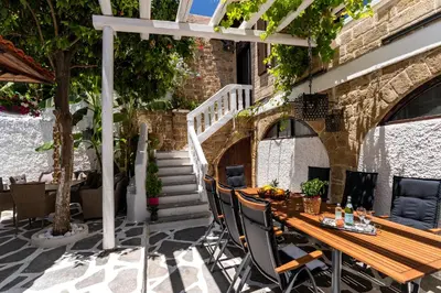a wooden table and chairs on a patio at Letty's House - Old Town Luxury Mansion in Rhodes Town