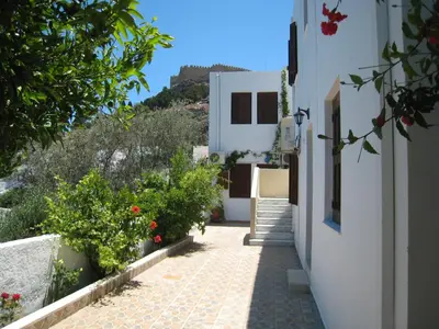 a walkway leading to a house with flowers at Eleftheria Lindian Studios II in Líndos