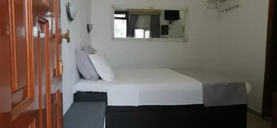 a small bedroom with a bed and a mirror at Eleftheria Lindian Studios II in Líndos