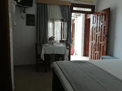 a bedroom with a table and a sink in a room at Eleftheria Lindian Studios II in Líndos