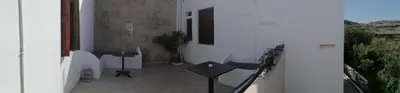 a balcony with a table and a potted plant at Eleftheria Lindian Studios II in Líndos