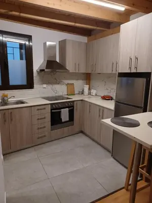 a kitchen with wooden cabinets and a stove top oven at Niochori apartments 1 in Rhodes Town