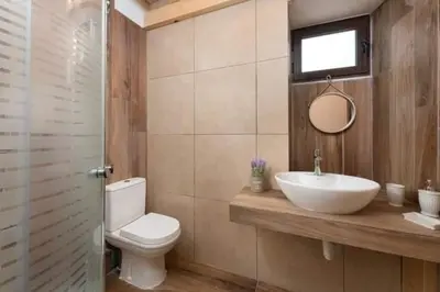 a bathroom with a sink and a toilet and a mirror at Niochori apartments 1 in Rhodes Town