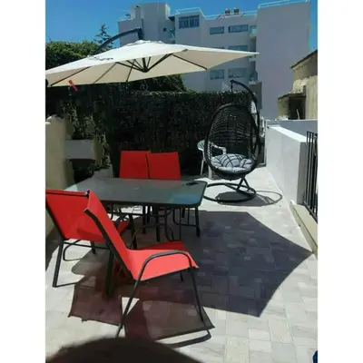 a patio with a table and chairs and an umbrella at Niochori apartments 2 in Rhodes Town