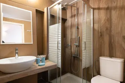 a bathroom with a sink and a shower and a toilet at Niochori apartments 2 in Rhodes Town