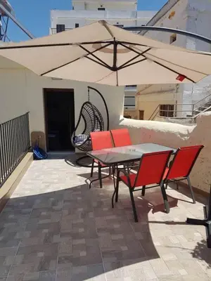 a patio with a table and chairs and an umbrella at Niochori apartments 2 in Rhodes Town