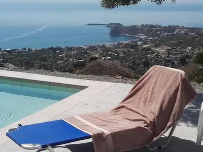 a towel sitting on a chair next to a swimming pool at Bouganville apartment Stegna in Archangelos