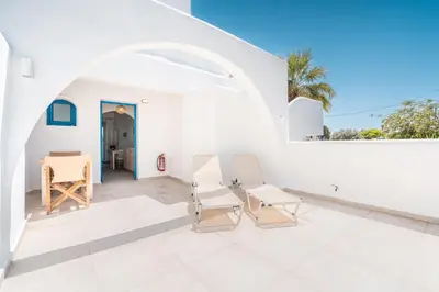 a patio with two chairs and a table at Studios Maria Christina in Faliraki