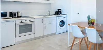 a kitchen with white appliances and a wooden table at Dias Luxury Homes in Koskinou