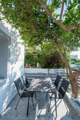 a table and chairs on a patio under a tree at Dias Luxury Homes in Koskinou