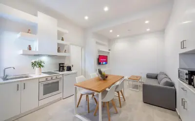 a kitchen and living room with a table and a couch at Dias Luxury Homes in Koskinou