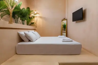 a bedroom with a bed with white pillows and a tv at Legato House in Rhodes Town