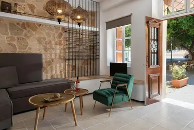 a living room with a couch and a table and chairs at Legato House in Rhodes Town