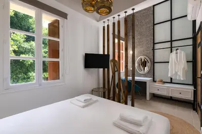 a white room with a bed and a mirror at Legato House in Rhodes Town