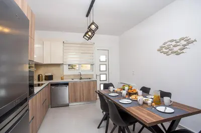 a kitchen with a wooden table and chairs in a room at Kalathos Sea View House in Kalathos