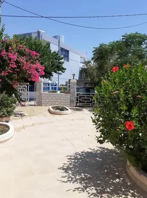 a courtyard with pink flowers and a building at Sea Breeze 2 in Haraki