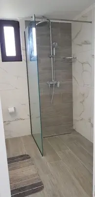 a bathroom with a shower with a glass door at Sea Breeze 2 in Haraki