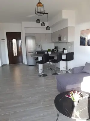 a living room with a couch and a kitchen at Sea Breeze 2 in Haraki