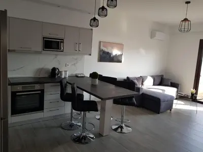 a kitchen and living room with a table and a couch at Sea Breeze 2 in Haraki