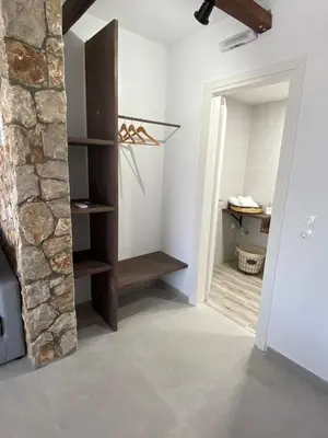 a room with a stone wall and a door to a bathroom at Oliva in Faliraki
