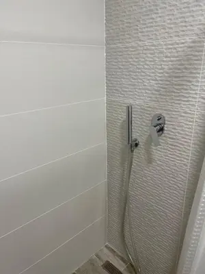 a shower with a hose in a bathroom at Oliva in Faliraki