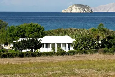 a white house in the middle of the ocean at Exclusive apartment in Ecovilla on the beach in Apolakkiá