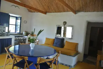 a living room with a table and a couch at Exclusive apartment in Ecovilla on the beach in Apolakkiá