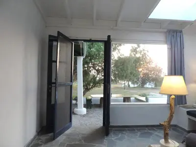 an open door to a room with a window at Exclusive apartment in Ecovilla on the beach in Apolakkiá
