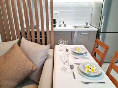 a table with two plates and wine glasses on it at Monte Smith City Home in Rhodes Town