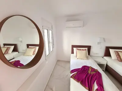 a white room with two beds and a mirror at Monte Smith City Home in Rhodes Town