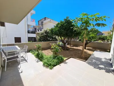 a patio with a table and chairs and trees at Monte Smith City Home in Rhodes Town