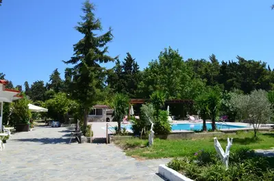 a resort with a swimming pool and a tree at Artemis Studios - Pool and garden in Koskinou
