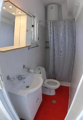 a bathroom with a white sink and a toilet at Artemis Studios - Pool and garden in Koskinou