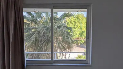 a window with a view of a palm tree at Artemis Studios - Pool and garden in Koskinou