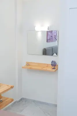 a white wall with a wooden shelf on it at AS ALESIAS SUITES.Room 12. in Rhodes Town