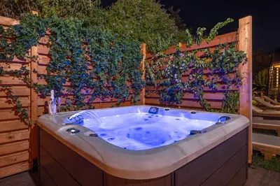 a jacuzzi tub in front of a fence at Prestige Residence Rhodes in Ialyssos
