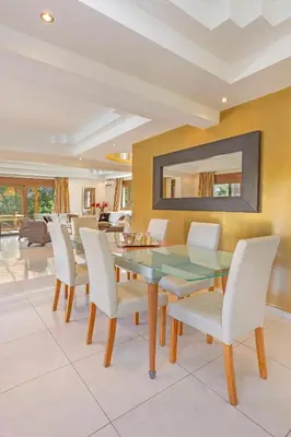 a dining room with a glass table and white chairs at Prestige Residence Rhodes in Ialyssos