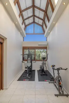 an indoor gym with exercise equipment and a glass ceiling at Prestige Residence Rhodes in Ialyssos